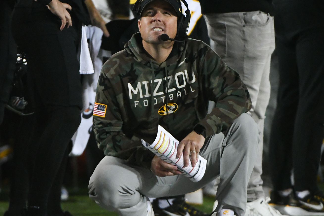 eli drinkwitz kneeling on the sideline